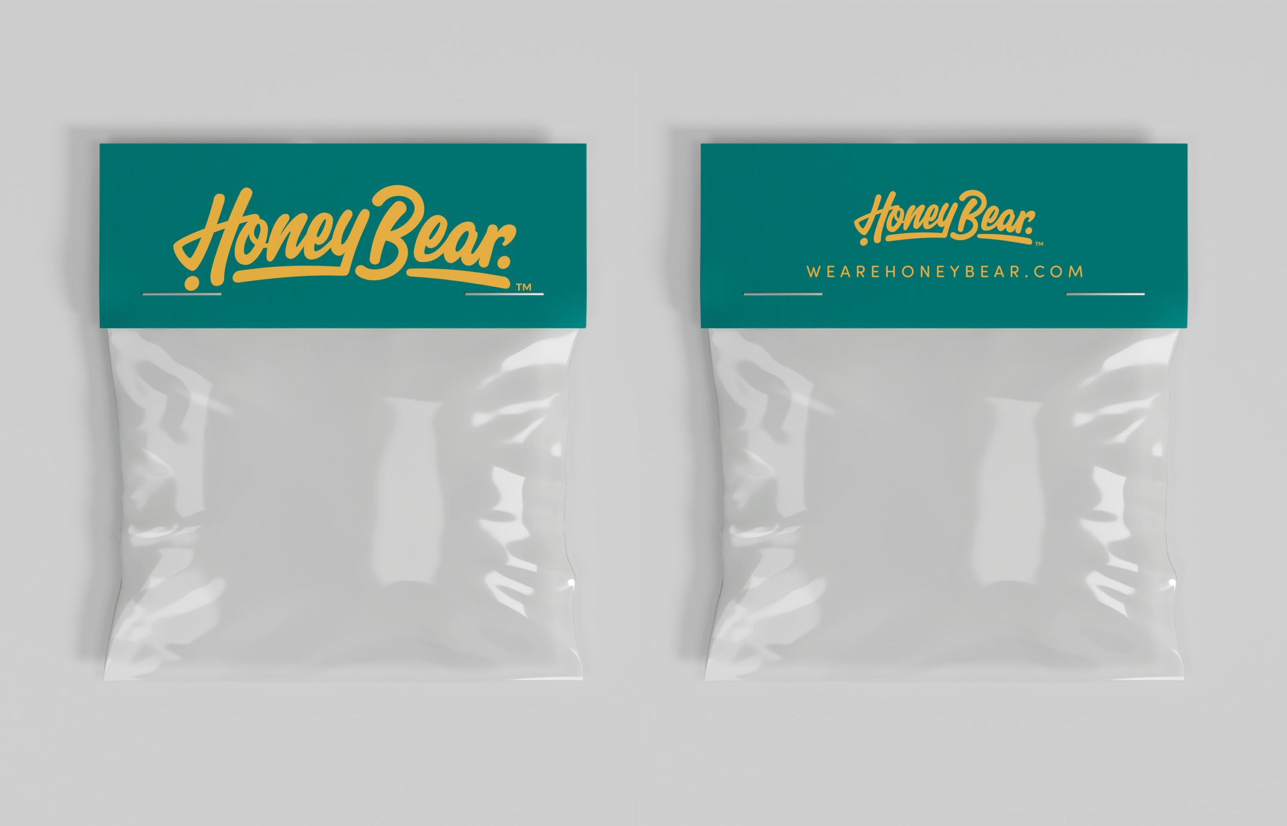 A side-by-side product mockup displaying both the front and back of a teal cardstock bag topper for Honey Bear stickers. The left side (front) features a large yellow script logo, while the right side (back) shows a smaller logo and the website URL, both stapled to clear poly bags against a light grey background.